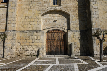 Fototapeta premium Entrance of San Miguel Church in Pina de Campos Palencia with dome and wooden doors