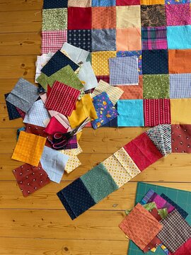Many square colorful cotton patches for a quilt and patchwork blanket are just being selected put together