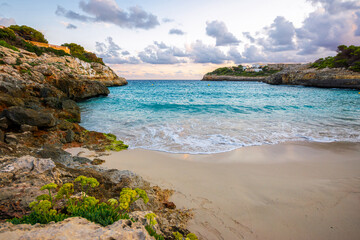 Turquoise water and sandy beach in Cala Anguila bay at sunset Mallorca Spain