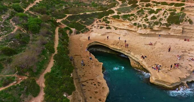 Aerial view St Peter's Pool in Malta. A famous beach in Malta for adrenaline junkies and diving into crystal clear waters, popular among tourists and young people