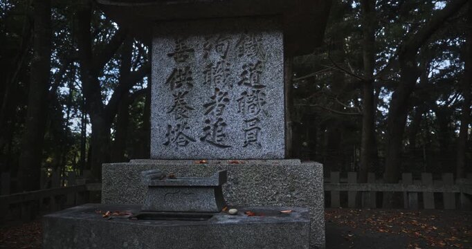 Ancient stone in forest with Japanese text on it - steady cam shot