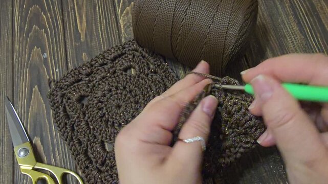 A crochet pattern of brown squares, perfect for home decor and fashion.