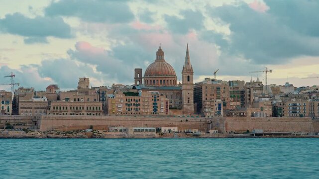 View of Valletta's of Capital City of Malta at sunny day. Marsamxett Harbour with the view on Valletta Saint Paul's Anglican Cathedral. Timelapse
