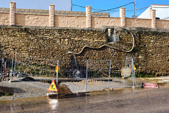 View of water cascading from a stone wall, creating a shimmering spectacle in the streets below, Setenil de las Bodegas, Andalusia, Spain.