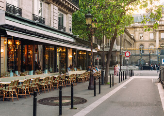 Fototapeta premium Cozy street with tables of cafe in Paris, France. Cityscape of Paris. Architecture and landmarks of Paris.