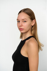 Naklejka premium A Natural Portrait of a Young Woman with Long Hair Against a Minimalist White Background Showcasing Pure Beauty and Confident Expression