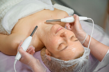 Naklejka premium Woman receiving facial treatment at spa