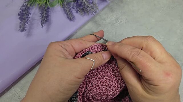 Knitted round lilac placemats on a gray background. Interior decor. Green plates.