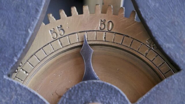 Ticking gearwheel with arrow pointer of an ancient clock