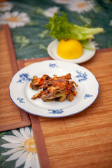 A Baked Vegetable Casserole of Broccoli with Potato, Sweet Bell Red Pepper, Chicken, Tomatoes and Cheese on Plate on Kitchen Table. Selective Focus.