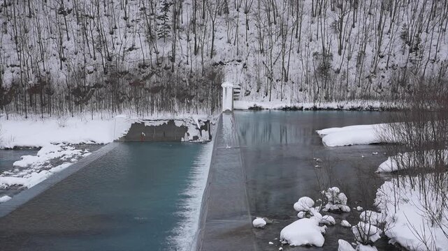 Aerial View of Shirogane Blue Pond Dam with Snowy Forest and Cobalt Blue Water in Winter, Hokkaido