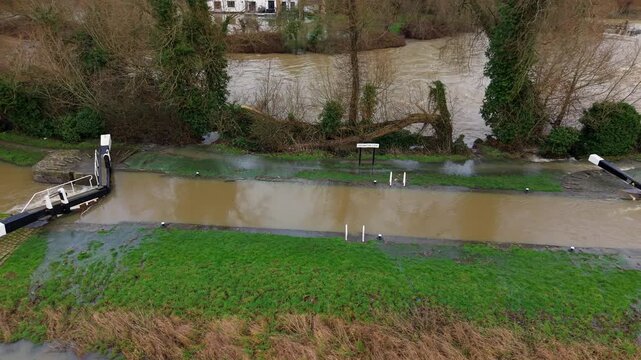 Aerial view of floodwaters inundating green land, creating a stark contrast between the natural landscape and the encroaching waters, Leicester, England, United Kingdom.