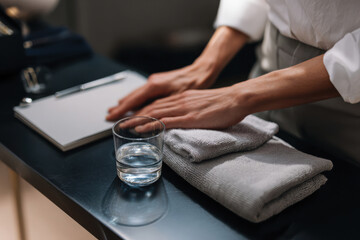 Fototapeta premium A focused person arranges tools and a glass of water on a table, emphasizing the importance of organization and preparation in a workspace to enhance productivity.