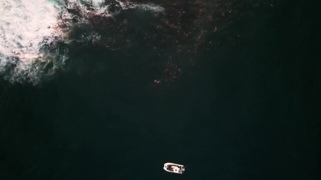 Aerial view of the dark blue ocean water clashing with foamy white waves, creating a mesmerizing contrast of colors and textures, Cape Town, Western Cape, South Africa.