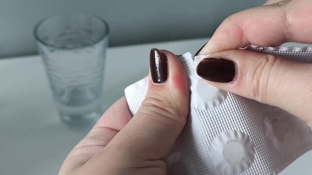 A woman's hands open a pack of pills. Taking medications for treatment. Health. Exacerbation of ARVI, ARI