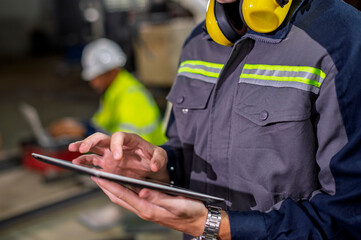 Robotics control engineers setting and maintain spare parts of industrial robot arm controller in production plant factory