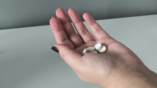 The pills are pouring into my arm. Taking tablets, vitamins. Treatment of diseases. ARVI. ARI. Uncontrolled pill intake concept