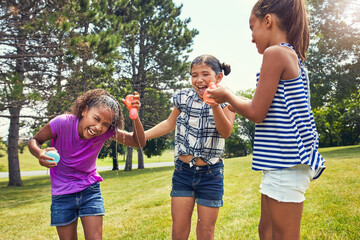 Laughing, water balloon and children outdoor for playing, games and fun activity on weekend....