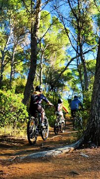 family riding in mountain bike in a forest, father and children