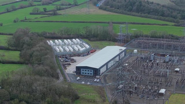 Aerial view of Enderby Substation's Battery Energy Storage Systems (BESS) amidst green fields and grey infrastructure, Enderby, United Kingdom.