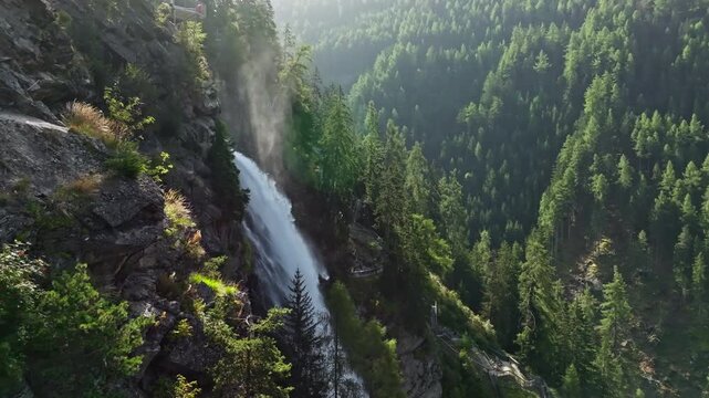 Drone view of Stuibenfall waterfall surrounded by alpine mountains and pine forests highlighting pristine nature landscapes and popular tourism in Austria
