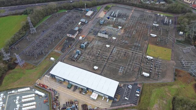 Aerial view of Enderby Substation National Grid, a symphony of metal structures against a backdrop of green fields, Enderby, United Kingdom.