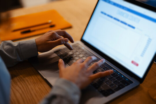 A person's hands type on a laptop keyboard, using a character counter tool to analyze text.