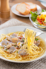 フォークで持ち上げたボンゴレビアンゴのスープパスタ