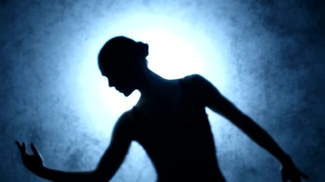 Silhouette of a Dancer in Motion Against a Blue Background.
