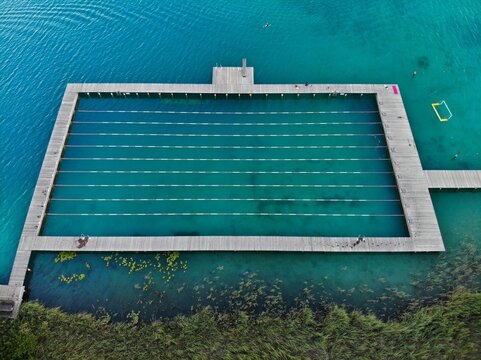 Austria drone view. Natural swimming pool on Lake Faak (Faaker See) in Carinthia state.