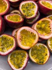 Fresh passion fruit cut in half for catering and event presentation, showcasing vibrant pulp and seeds, ideal for buffet service, dessert decoration, and commercial food styling.