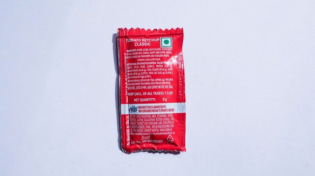 Small sachet pack of Veeba Tomato ketchup sauce isolated on white background back view