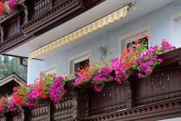 Fototapeta premium Balcony flower decoration in Salzburg, Austria. Pots of red geranium and surfinias.
