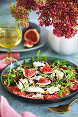 Delicious fresh fig carpaccio with burrata or stracciatella or mozzarella cheese and arugula salad