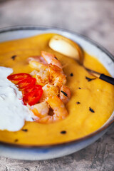 Delicious fresh cooking hot pumpkin and sweet potato soup, served with prawns, chili and stracciatella cheese