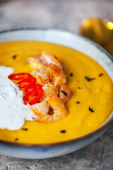 Delicious fresh cooking hot pumpkin and sweet potato soup, served with prawns, chili and stracciatella cheese
