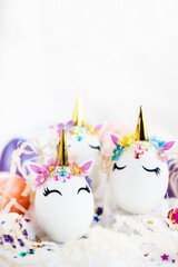 Easter eggs in the form of a unicorn on white background, copy space for text, close-up