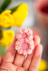 Close-up of beautifully decorated sweets in shape of number eight in woman hand, Women&rsquo;s Day  spring holiday concept