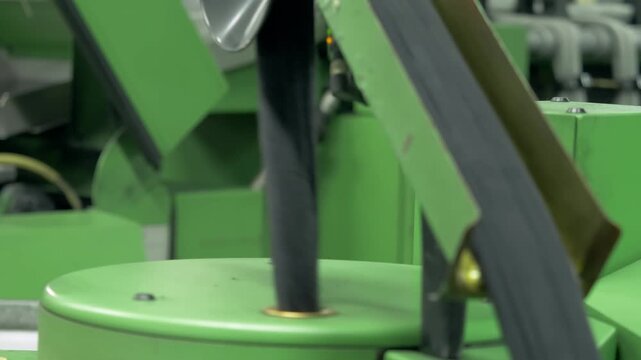 Premium black wool fibers move through industrial textile machinery during processing. The factory production line transforms the raw wool material.