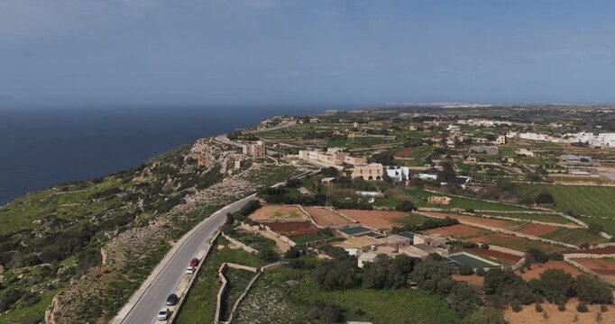 Aerial view of the rugged Dingli Cliffs contrasting with the cultivated fields, winding roads, and scattered buildings, Dingli, Malta.