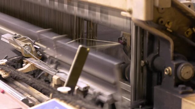 Industrial textile machines process wool fibers along the production line. The manufacturing workflow transforms raw wool into fabric material.
