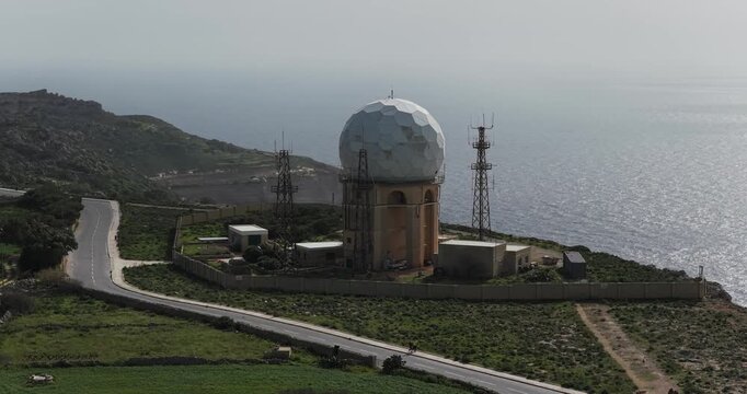 Aerial view of the spherical Dingli Radar dome, its stark white contrasting with the muted greens and browns of the landscape, Dingli, Dingli Radar, Malta.