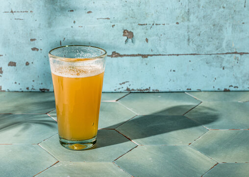 Light beer in glass on aqua tiles