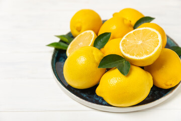 Lemon on a wooden table. Fresh lemon with a slice. Fresh lemon with citrus leaves. Lemon juice. Food and drink ingredients preparing. Healthy eating. Vitamin C. Space for text.