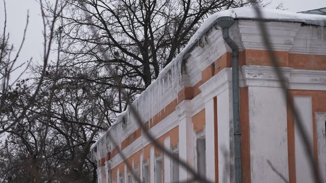Large dangerous icicles hanging from the roof of building