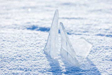 Close-up of sharp ice fragments rising from powdery snow