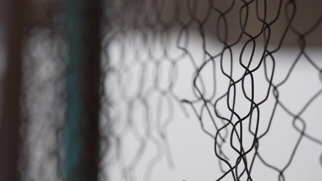 Close-up of old rusty wire mesh with shallow depth of field. Abstract metal pattern forming a textured background. Corroded industrial netting with selective focus creating a moody minimalistic visual