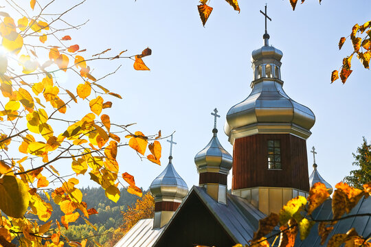 Towers of an old wooden church in the autumn sun