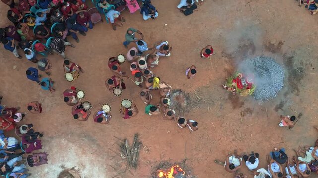 Top drone view of Theyyam ritual at a traditional Kavu in North Malabar, Kerala. The sacred performance unfolds among a dense gathering of devotees