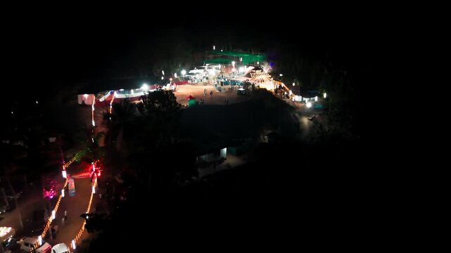 A dramatic aerial drone shot capturing a Theyyam ritual at a sacred Kavu temple in North Malabar, Kerala